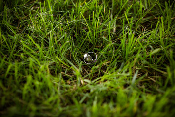 wedding rings in hand. Two wedding rings on the floor with contrast wedding rings on floor, on ground, on piano, in hand on grass or a stones,