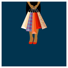 Swarthy woman holding speckled shopping bags on the dark blue background.