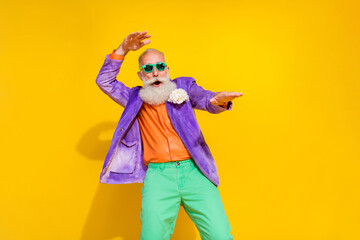 Photo of overjoyed senior man wear trendy bright costume celebrate event birthday relax rest empty space isolated yellow color background