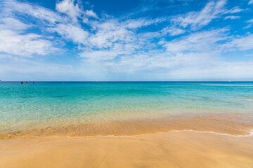 Fototapeta na wymiar Turquoise ocean view of Jandia beach (Morro Jable). Landscape view of beach sea in summer day. At Jandia beach, Pájara, La Palma, Fuerteventura, Canary Islands. On 22 June 2022