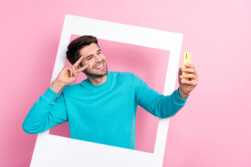 Photo portrait of attractive young guy polaroid photo frame selfie hold device wear trendy blue clothes isolated on pink color background