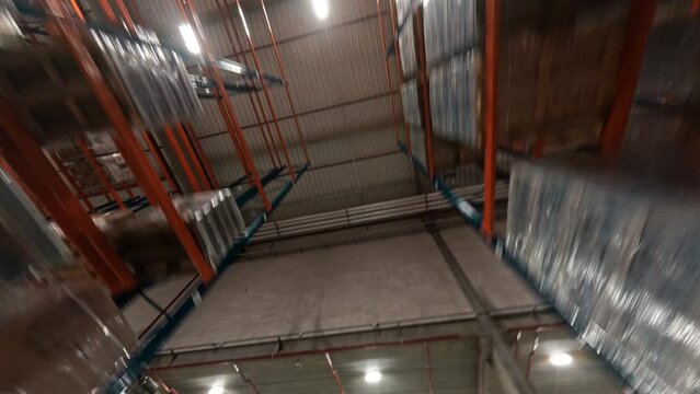 Maneuverable FPV flight inside modern large warehouse. View in huge logistic center product distribution storage. Shelves with goods.