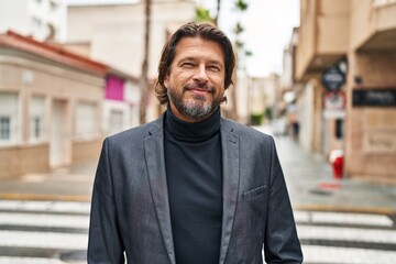 Middle age man smiling confident standing at street