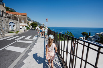 Family tourist walking at famous village Positano on vacation in Italy.