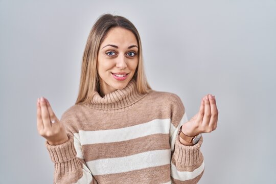Young blonde woman wearing turtleneck sweater over isolated background doing money gesture with hands, asking for salary payment, millionaire business