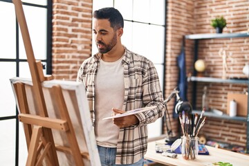 Young hispanic man drawing at art studio