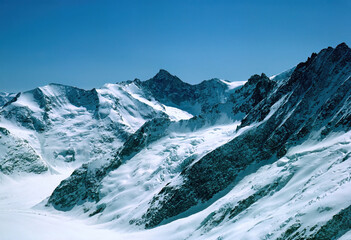 Panorama of snowy mountains and high alpine peaks in wintery Bernese Oberland in Switzerland