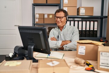 Senior man working at small business ecommerce wearing headset happy face smiling with crossed arms looking at the camera. positive person.