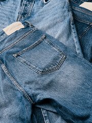 Stack of different  jeans on white background. Recycling old blue denim jeans arranged in stack