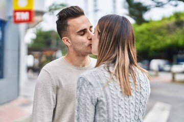 Obraz premium Man and woman couple standing together kissing at street