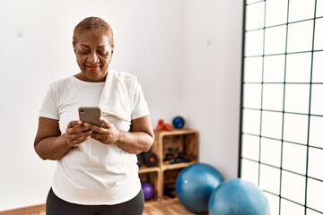 Senior african american woman smiling confident using smartphone at sport center