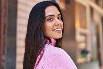 Young hispanic woman smiling confident standing at street