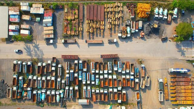 Drones are flying over truck parking lots, trucks containers with truck trailers. transportation and business industry. Import and export concept. tropical in southeast asia. aerial view. 4K footage
