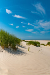 Sandy Beach on Wangerooge island in National Park, natural reserve and World Heritage “Wattenmeer“. North sea in Ostfriesland Germany with dunes and grass is a popular tourist destination.