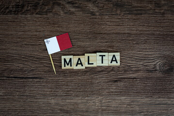 Fototapeta na wymiar Malta - wooden word with maltese flag (wooden letters, wooden sign)