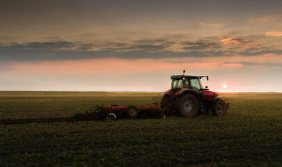 Fototapeta premium Farmer preparing his field in a tractor