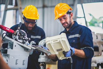 Engineers team mechanic using computer controller Robotic arm for welding steel in steel factory...