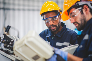 Engineers team mechanic using computer controller Robotic arm for welding steel in steel factory...