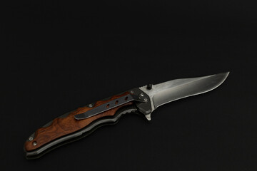 Black metallic hunting knife on black background 