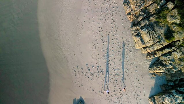 Happy Couple Running On The Shore Of A Sandy Beach In Praia de Caion, Spain. Aerial Topdown