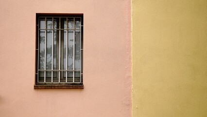 Fototapeta na wymiar window with grille in colored facade