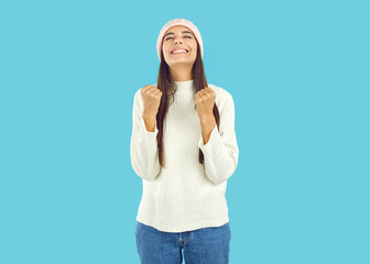 It's finally winter season. I'm so happy. Pretty young woman in warm white hat, jumper and jeans...