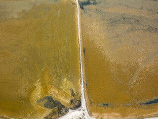 immagine panoramica di uno stagno ripreso da un drone, in mezzo passa un stradine he separa le acque.