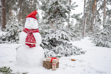 Christmas snowman in red scarf, fabulous snowy day. Beautiful winter background.