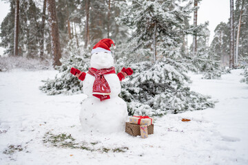 Christmas snowman in red scarf, fabulous snowy day. Beautiful winter background.