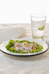 Ceviche, typical fish-based dish of Peruvian cuisine on white tablecloth.