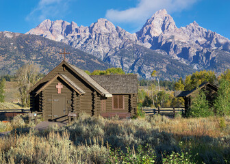 Fototapeta na wymiar Exterior entrance to the historic Chapel of the Transfiguration in front of mountain range at Grand Teton National Park in Wyoming