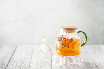Glass teapot with hot citrus tea from oranges, lemons, apples, mandarins and thyme. Healthy drink...
