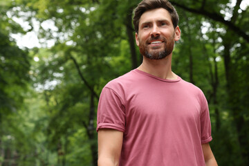 Portrait of handsome bearded man in park, space for text