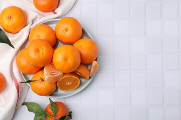 Fresh juicy tangerines on white tiled table, flat lay. Space for text