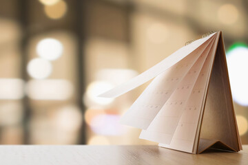 desk calendar on table with blurred bokeh background appointment and business meeting concept