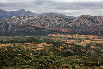 Fototapeta premium Farms and green fields with Mountain Landscape Background. Near Dorgali, Sardinia, Italy.