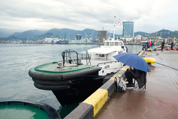 Fisherman catches fish in the seaport of Batumi on a cloudy autumn day