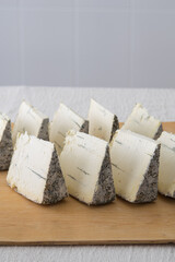 Blue cheese pieces on a wooden board, selective focus. Dorblu danishn blue roquefort stilton craft cheese.