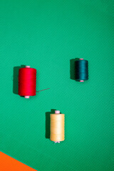 Three coils with colored threads on a colored background