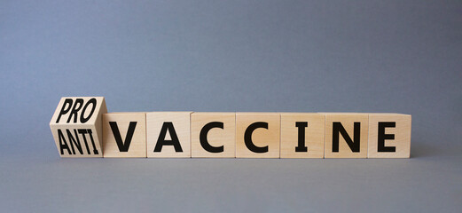 Pro-vaccine vs Anti-vaccine symbol. Turned wooden cubes with words Anti-vaccine vs Pro-vaccine. Beautiful grey background. Medicine concept. Copy space