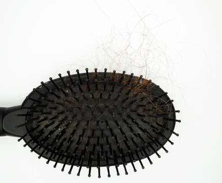 Hair brush with tufts of hair on it isolated on white. Hair loss, hair care.