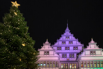 Christmas market in the evening in the city Paderborn, Germany. The town hall is colourfully...