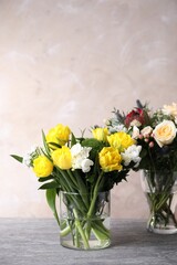 Beautiful bouquets with fresh flowers on grey table