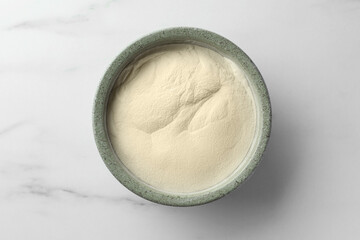 Bowl of agar-agar powder on white marble table, top view