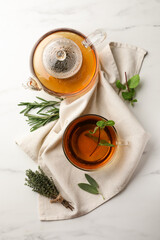 Aromatic herbal tea with rosemary, sage, thyme and mint on white marble table, flat lay - obrazy, fototapety, plakaty