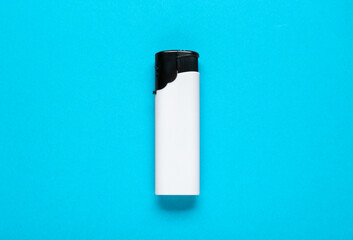 White plastic cigarette lighter on light blue background, top view