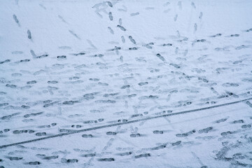 snowfall weather, snow and footprints in the snow on the city streets. The trampled fresh snow...