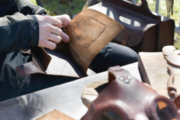 Leather stitching by hand. The master gives a workshop on the street to show how they work with...