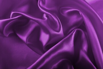 Deep, rich, purple colored satin. Folded and flowing background. Luxury fashion concept. Trend color 2022 - Velvet Violet