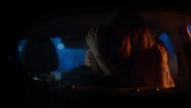 Police or security officer interrupts Caucasian couple passionately kissing on a backseat of a car